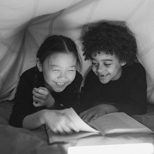 two children reading a book together